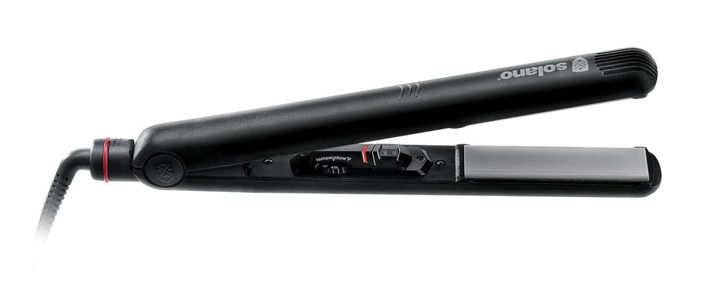 A close-up of a black flat iron with gray heating plates.